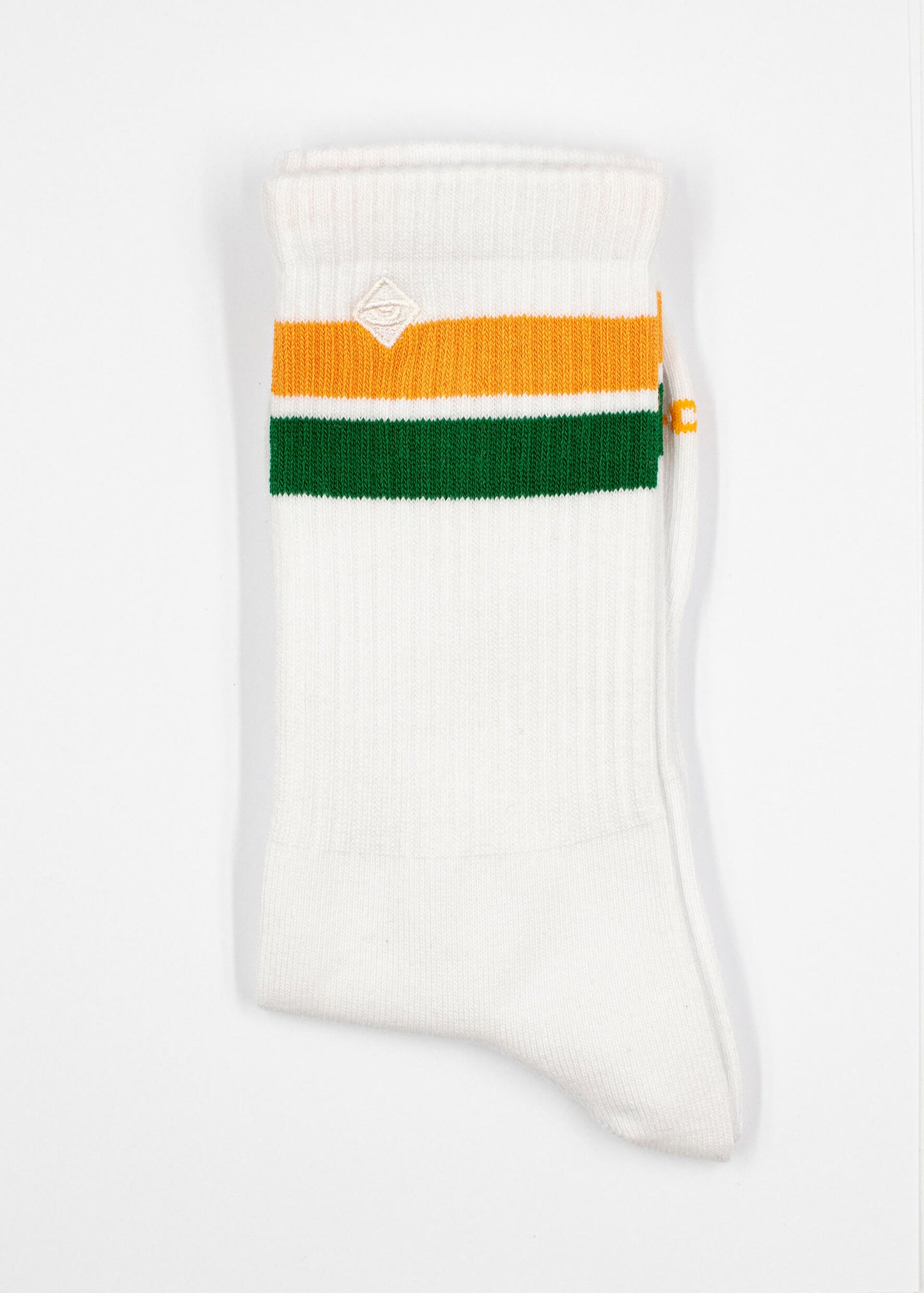 Eine einzelne weiße J.Clay Tennissocke mit orangefarbenen und grünen horizontalen Streifen im oberen Bereich auf weißem Hintergrund. Ein kleines weißes J.Clay-Logo ist oberhalb der Streifen aufgenäht.