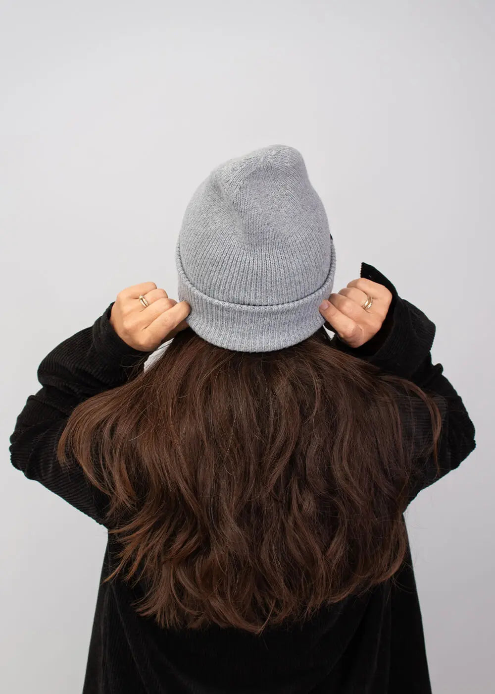 Person mit langen braunen Haaren in einem J.Clay Deep Cuffed Beanie Ash und schwarzer Jacke, mit Blickrichtung nach außen.