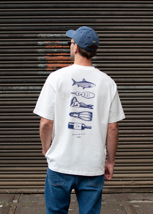 Eine Person in einem „J.Clay Ocean Kiss“-T-Shirt steht vor einem Metallrollladen.