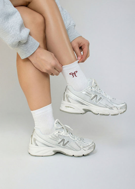 Person passt die J.Clay Cherry Bow - Midi Socken an und trägt weiße Turnschuhe.