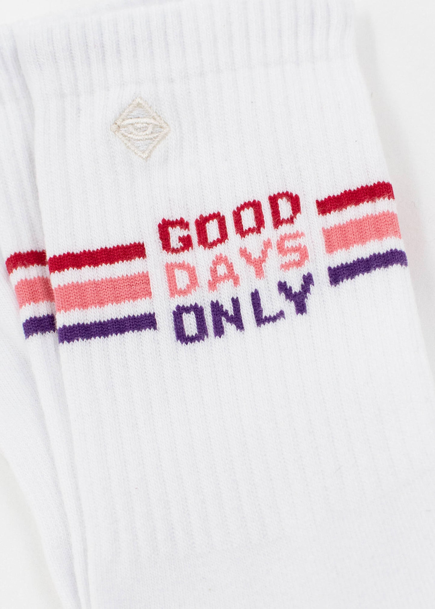 Ein Paar weiße Tennissocken von J.Clay mit roten und violetten Streifen und der Aufschrift "GOOD DAYS ONLY" in Rot am oberen Rand sowie cremefarbenen Zehen für mehr Stil. Ausgestellt auf einem schlichten weißen Hintergrund.