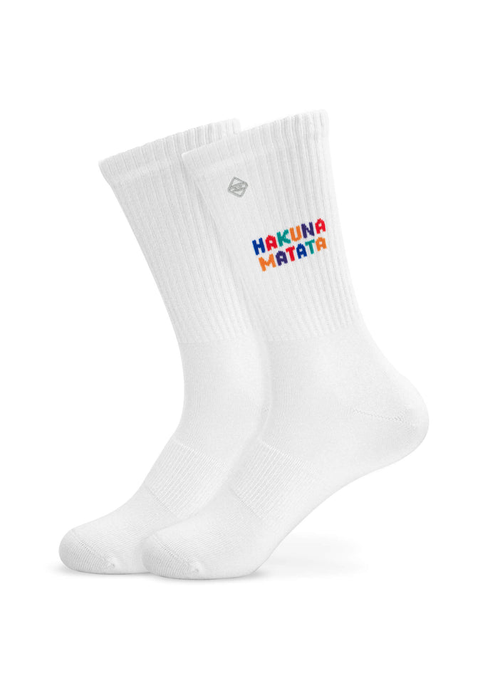 Ein Paar weiße J.Clay Tennissocken mit der Aufschrift "Hakuna Matata" in bunten, verspielten Buchstaben an der Oberseite.