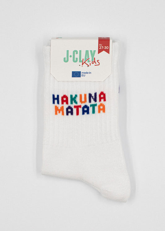 Ein Paar weiße J.Clay Kinder Tennissocken mit bunt gesticktem "HAKUNA MATATA" Text und einem J.Clay Kids Label. Ideale Kindersocken ab 5 Jahren für Komfort und spielerischen Stil.