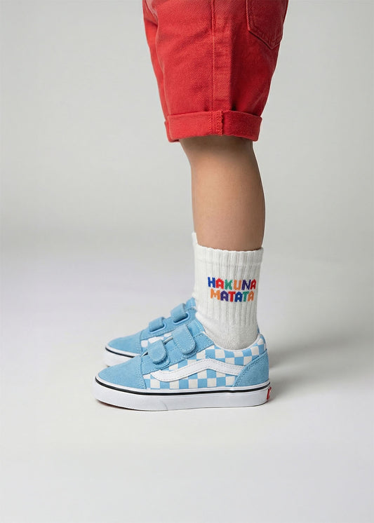 Kind in roten Shorts, blauen Turnschuhen und J.Clay Hakuna Matata - Mini-Socken.