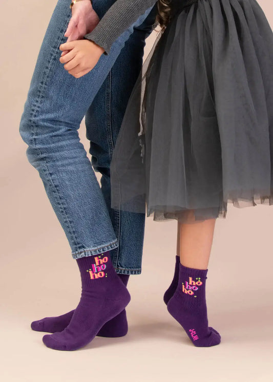 Zwei Paar „J.Clay Ho Ho Ho – Fam Pack“-Socken: eines in Jeans, eines in einem Tüllrock.