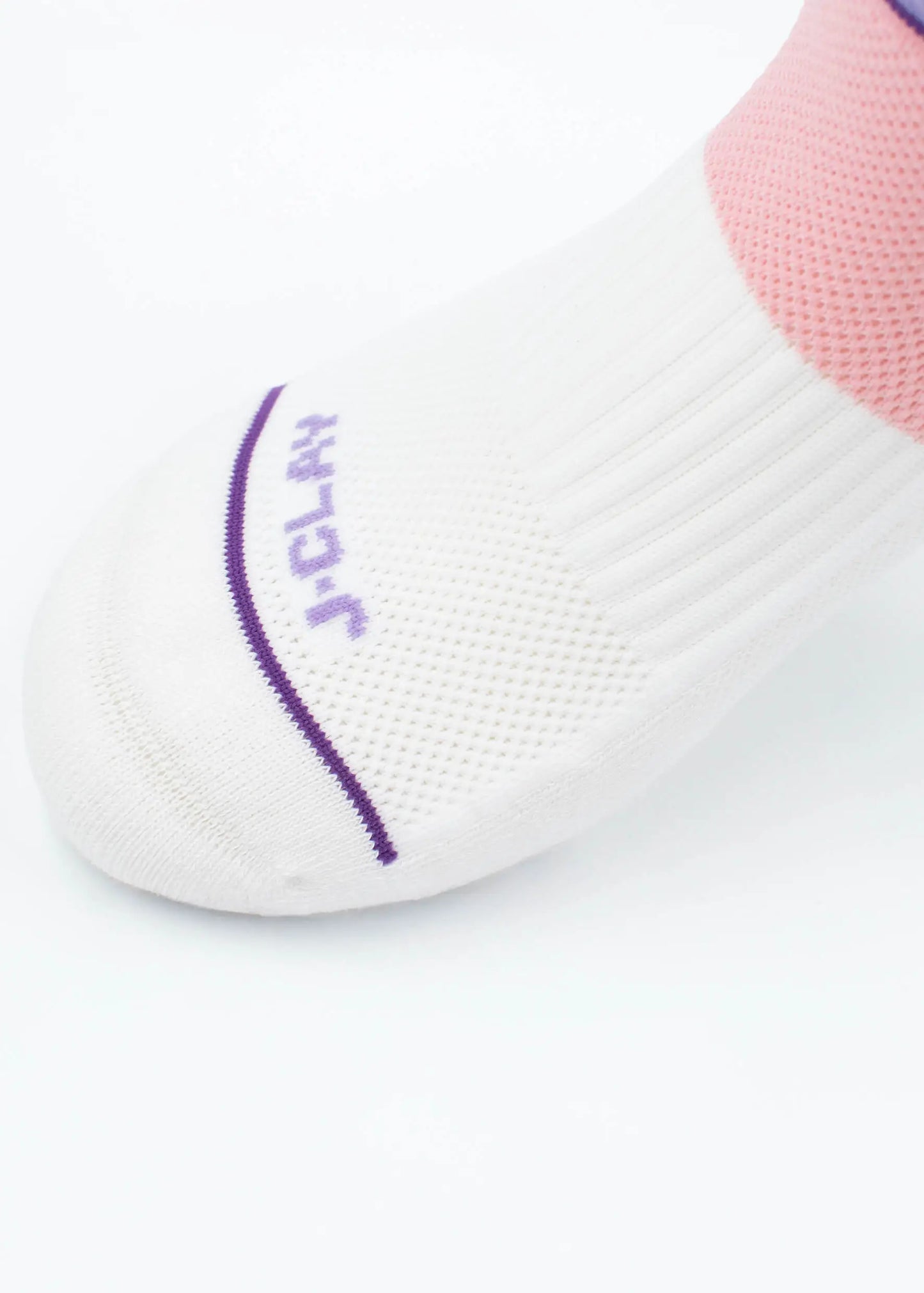 Eine Nahaufnahme eines Fußes in J.Clay Sportsocken mit lila Akzenten, "JCLAY"-Schriftzug in der Nähe der Zehen, einem rosafarbenen Bereich um den Knöchel und einer gepolsterten Sohle für zusätzlichen Komfort.