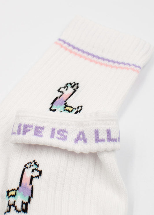 J.Clay Kinder Tennissocken in Weiß mit bunten Lama-Motiven und lila-pinkem Streifen. Am Bund steht "LIFE IS A LLAMA" in Lila. Perfekt ab 5 Jahren für verspielte Styles!.