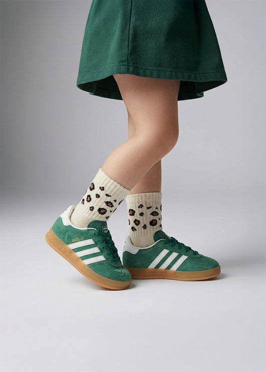 Person in grünem Rock trägt J.Clay Leo - Mini Babysocken und grüne Adidas-Sneaker.