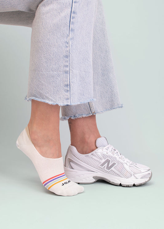 Person in ausgefransten Jeans, weißen Sneaker Socken und J.Clay Multi Stripes - Füßlinge.
