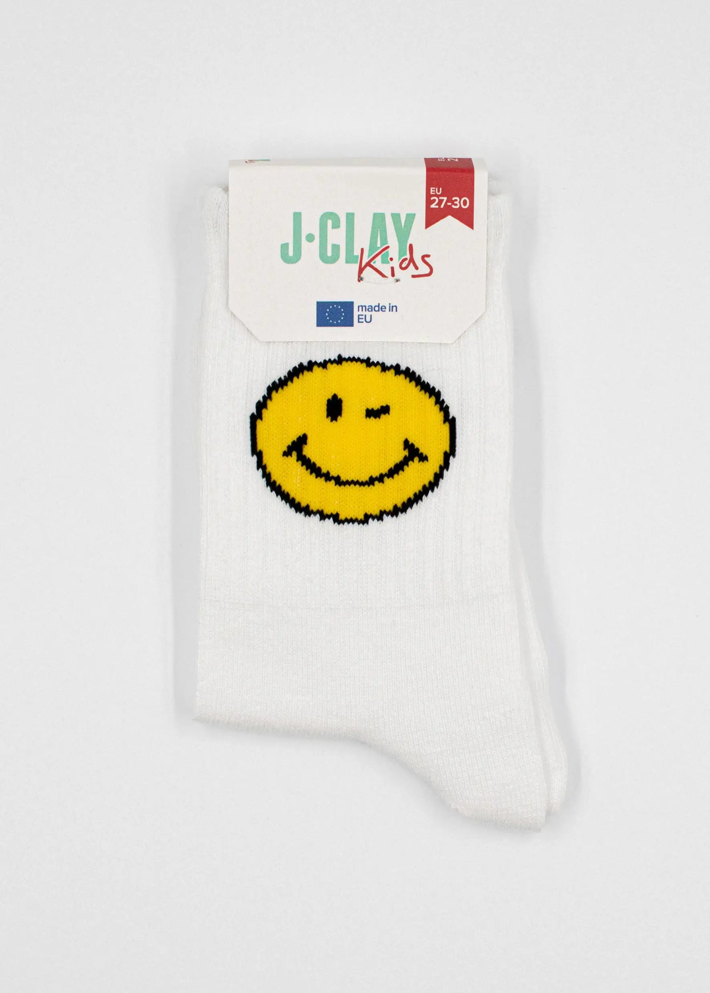Ein Paar weiße J.Clay Kinder Tennissocken mit einem gelben Smiley-Gesicht, EU-gefertigt in Größe 27-30. Verpackt mit einem J.Clay Kids Label - ideale Socken für Kinder ab 5 Jahren.