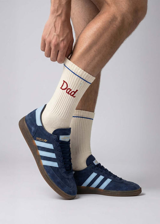 Person trägt blaue J.Clay Dad Turnschuhe und weiße Socken mit der Aufschrift Dad in Rot.