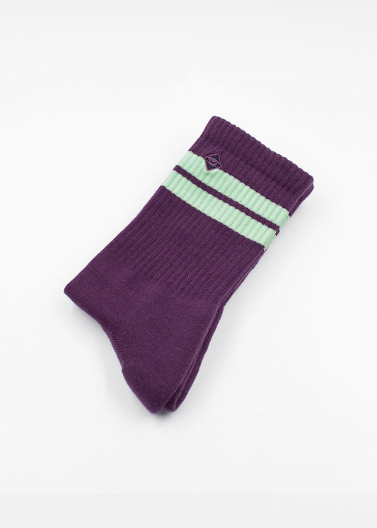 Ein Paar violette Tennissocken von J.Clay mit zwei hellgrünen Streifen in der Nähe des oberen Randes, sauber gefaltet auf weißem Grund.