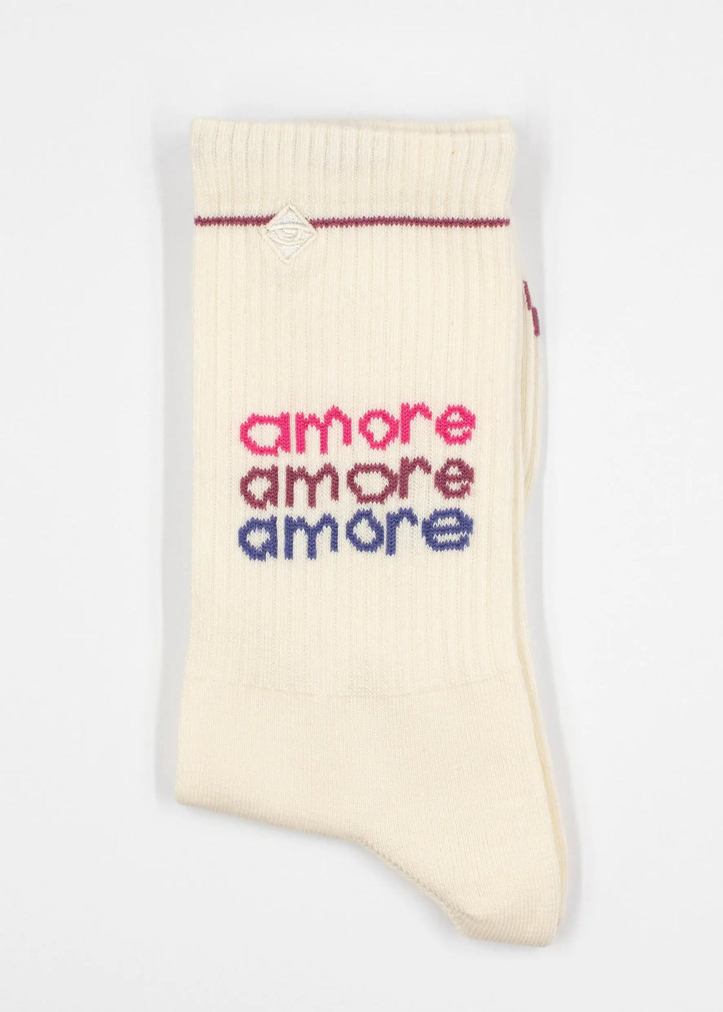 Eine einzelne cremefarbene Tennissocke von J.Clay mit dem dreimaligen Schriftzug "amore" in Rosa, Rot und Blau an der Seite und einem dünnen roten Streifen am oberen Bündchen.