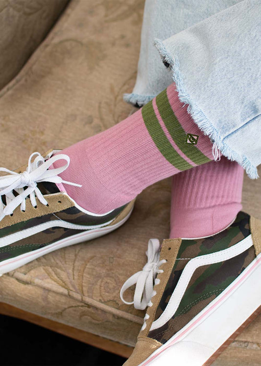 Ausgefranste Jeans, gestreifte rosa Socken, Vans im Camouflage-Look und der „True Pack“ von J.Clay auf einem gemusterten Sitz.