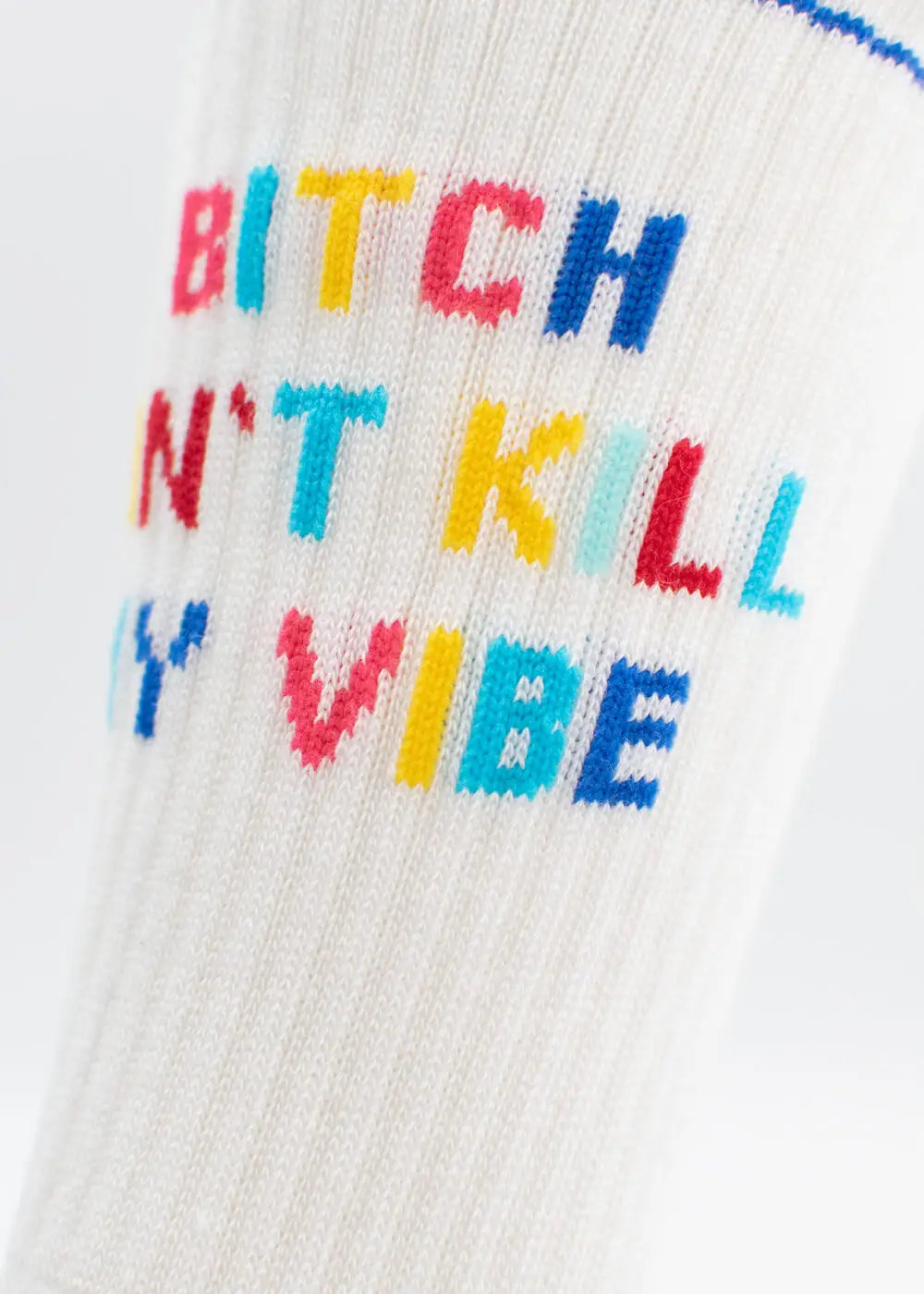 Eine Nahaufnahme der weißen gerippten J.Clay Tennissocken mit dem bunten gestickten Text "Bitch Dont Kill My Vibe" in roten, rosa, gelben, blauen und blaugrünen Buchstaben.