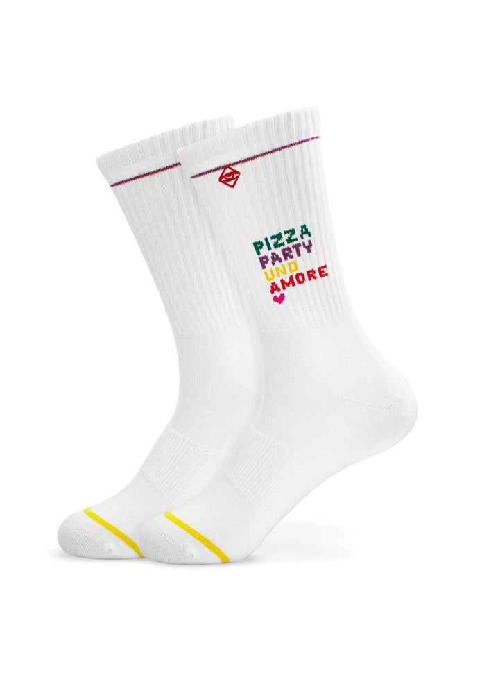 Zwei weiße J.Clay Tennissocken mit roten und gelben Zehenstreifen zeigen "PIZZA PARTY UNO & MORE" in roter und grüner Schrift sowie eine kleine rote Würfelgrafik in der Nähe des oberen Bündchens.