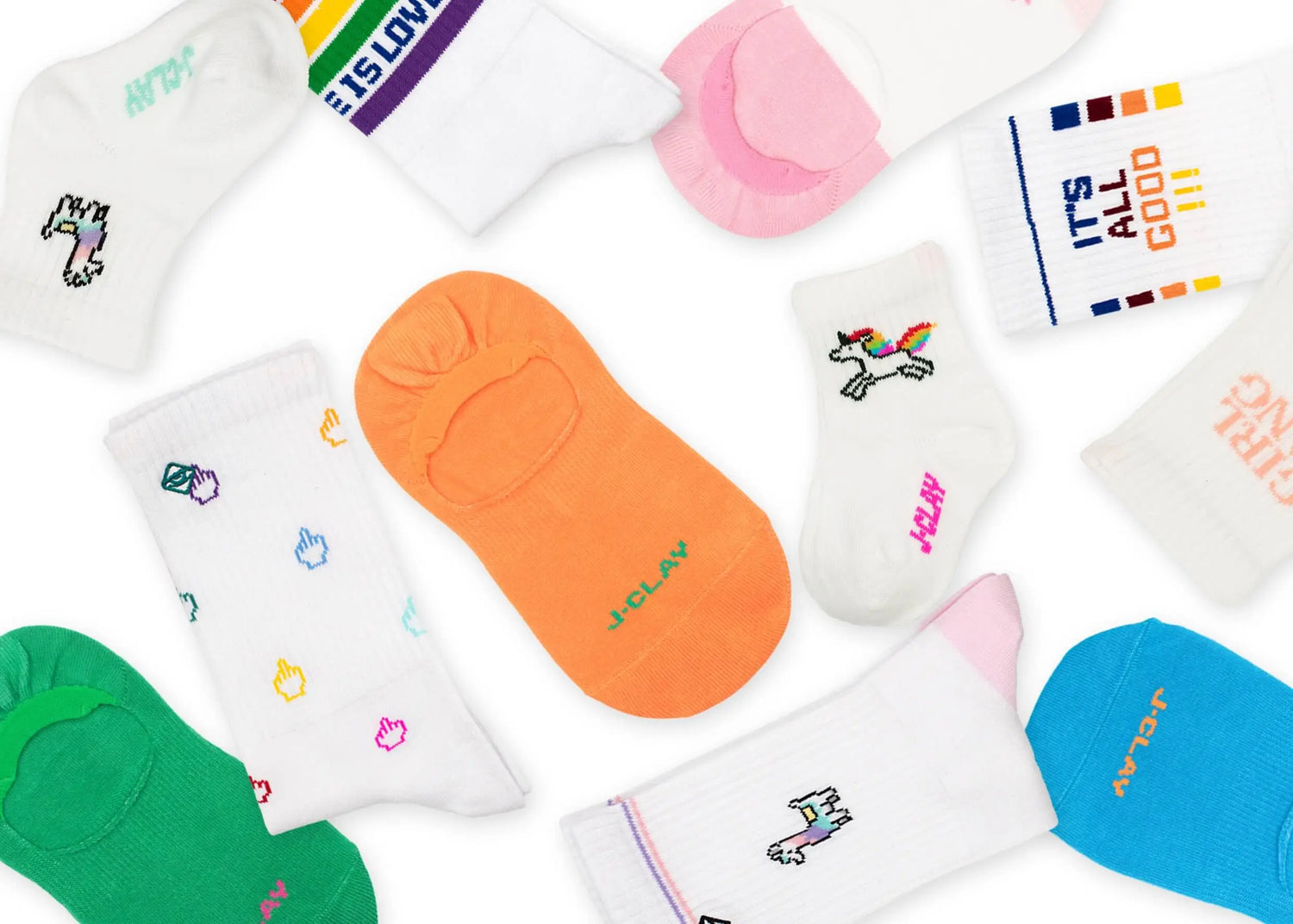 Auf einer weißen Fläche ist eine Vielzahl bunter Socken mit verschiedenen Farben, Mustern, Regenbögen, Einhörnern und positiven Botschaften verteilt.