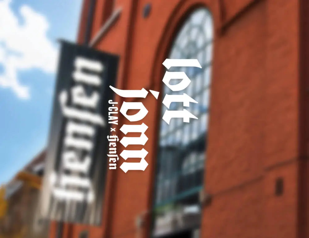 Eine verschwommene Außenszene zeigt ein Backsteingebäude mit hohen Bogenfenstern und einem vertikalen Banner mit der Aufschrift hensen in schwarzer Schrift. Der überlagerte weiße Text lautet: lott jonn J-CLAN x fencer.