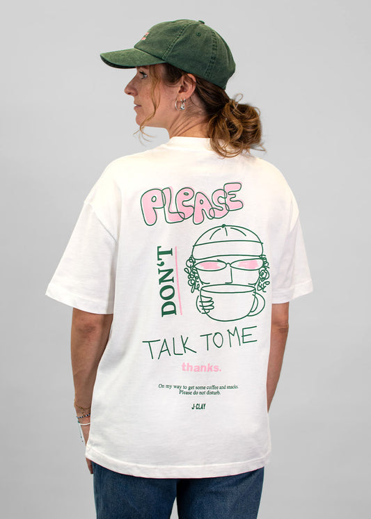 Eine Person mit Mütze und einem „J.Clay Please Don’t“-T-Shirt, die mit dem Rücken zur Kamera steht.