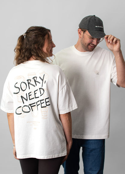 2 Unisex-T-Shirts von J.Clay mit der Aufschrift „Sorry, Need Coffee“; eines in der Farbe „Off-White“ mit der Aufschrift „SORRY, NEED COFFEE“ auf der Rückseite.