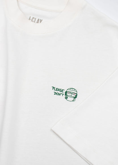 J.Clay „Please Don’t“ – Unisex-T-Shirt in Off-White, Oversize-Passform, mit grünem Schriftzug und Gesichtsillustration.