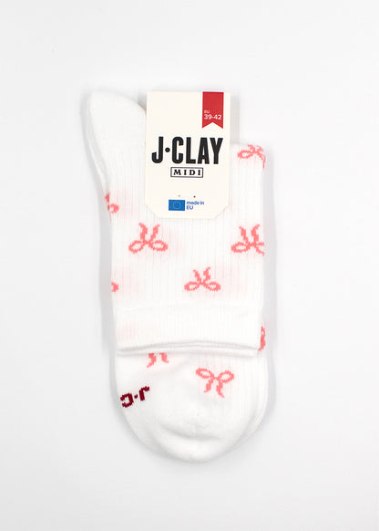 Bowtiful - Weiße Midi-Socken mit rosa Schleifen, gefaltet mit einem J.Clay-Etikett oben drauf.