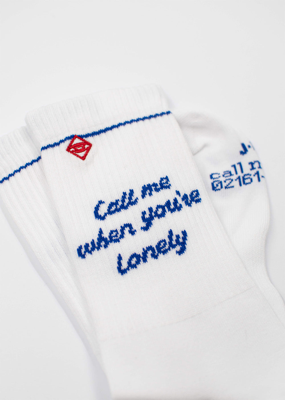 Weiße J.Clay Call Me Tennissocken mit blauem Schriftzug und kleinem roten Design.