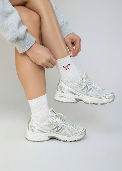 Person passt die J.Clay Cherry Bow - Midi Socken an und trägt weiße Turnschuhe.