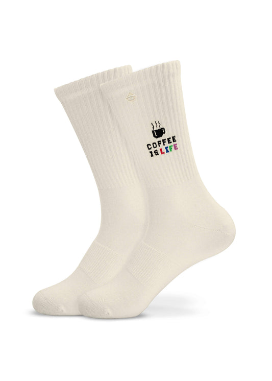 Ein Paar weiße gerippte J.Clay Tennissocken mit einer kleinen Kaffeetasse und dem Schriftzug "COFFEE IS LIFE" in schwarzer, rosa, grüner und blauer Schrift auf der Seite.