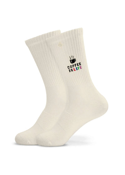 Ein Paar weiße gerippte J.Clay Tennissocken mit einer kleinen Kaffeetasse und dem Schriftzug "COFFEE IS LIFE" in schwarzer, rosa, grüner und blauer Schrift auf der Seite.