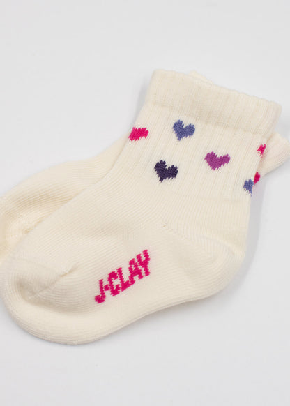 Cremefarbene J.Clay-Babysocken mit rosa, lila und blauem Herzmuster und dem Aufdruck "JCLAY" in Rosa auf der Sohle - perfekt für Kinder von 0-4 Jahren.