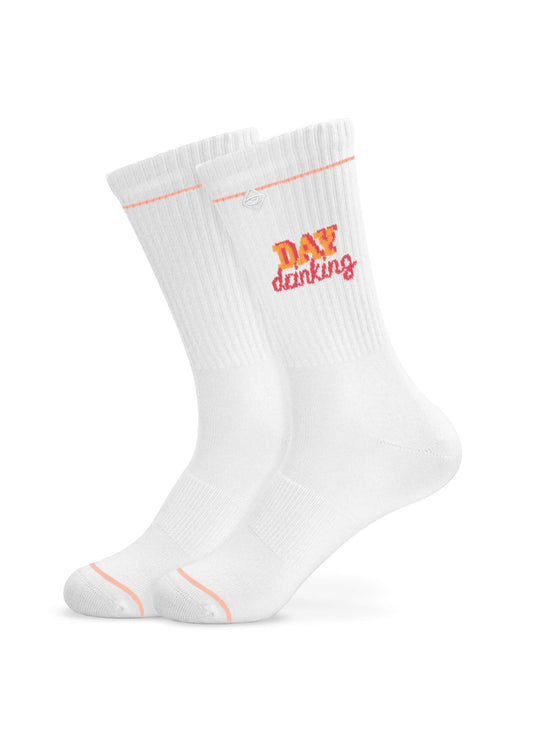 Ein Paar weiße, gerippte J.Clay Tennissocken mit dezenten rosa Akzenten und der Aufschrift "DAY drinking" in Gelb und Rosa am oberen Rand.