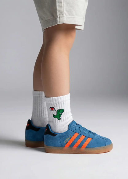 Person trägt blaue adidas Sneakers und weiße J.Clay Dino Love - Mini Kindersocken.