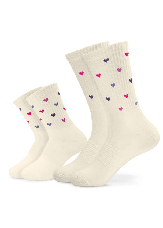 Zwei Paar J.Clay Partner-Look Socken, ein kleines und ein großes, in Creme mit rosa und lila Herzmustern. Beide Paare sind auf weißem Hintergrund abgebildet.