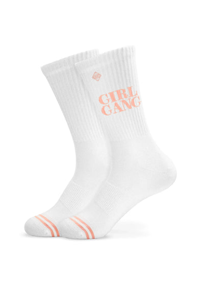 Ein Paar weiße J.Clay Tennissocken mit gerippten Bündchen, orangefarbenen Streifen in der Nähe der Zehen und einem orangefarbenen Aufdruck "GIRL GANG" an der Seite, abgebildet vor einem schlichten weißen Hintergrund.