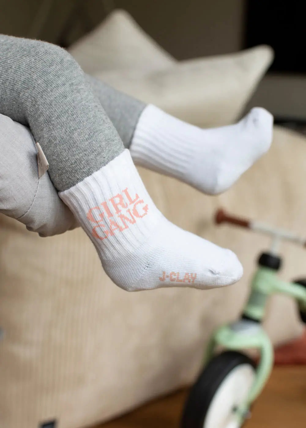 Kind sitzt am grünen Dreirad und trägt J.Clay Girl Gang - Mini Babysocken.