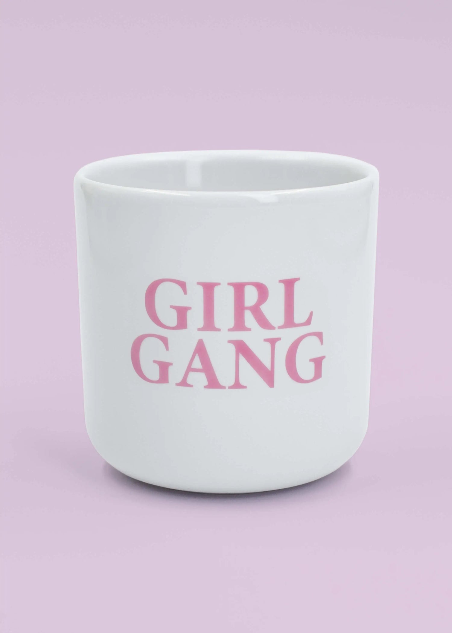 Die J.Clay Girl Gang - Tasse ohne Henkel zeigt bold pinke Schrift auf weißem Grund - ein perfektes Geschenk für die beste Freundin, stilvoll präsentiert vor zartem Rosa.