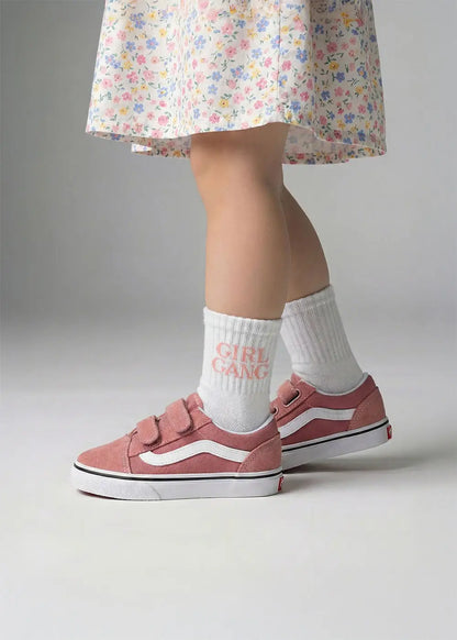 Sie trägt ein geblümtes Kleid, rosa Turnschuhe und J.Clay Girl Gang - Mini Socken.