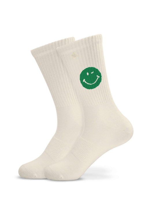 Ein Paar weiße J.Clay Tennissocken mit einer großen grünen Smiley-Grafik auf der Seite jeder Socke, die vor einem schlichten weißen Hintergrund gezeigt wird.