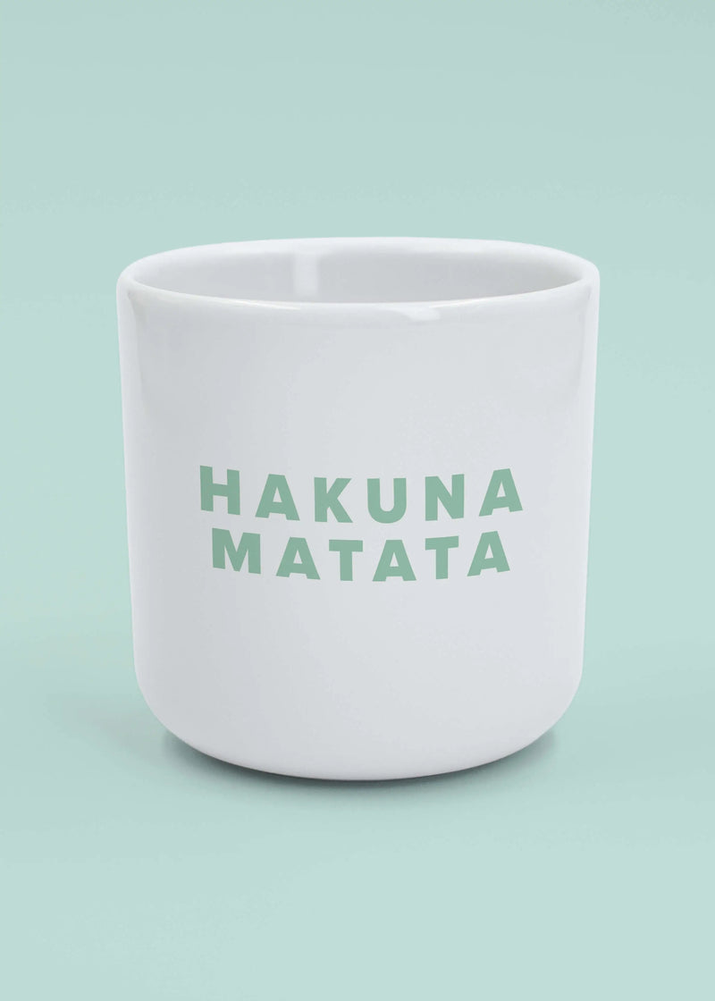J.Clay Hakuna Matata - Tasse mit grünem Schriftzug auf hellblauem Hintergrund.