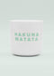 Eine weiße Keramik-Tasse ohne Henkel von J.Clay mit der Aufschrift "HAKUNA MATATA" in hellgrünen Großbuchstaben auf der Vorderseite vor einem hellen Hintergrund.