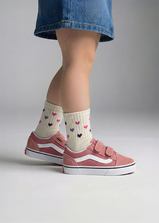Kind im Jeansrock trägt J.Clay Colour Hearts - Mini-Socken und rosa Turnschuhe, perfekt zum Verschenken.