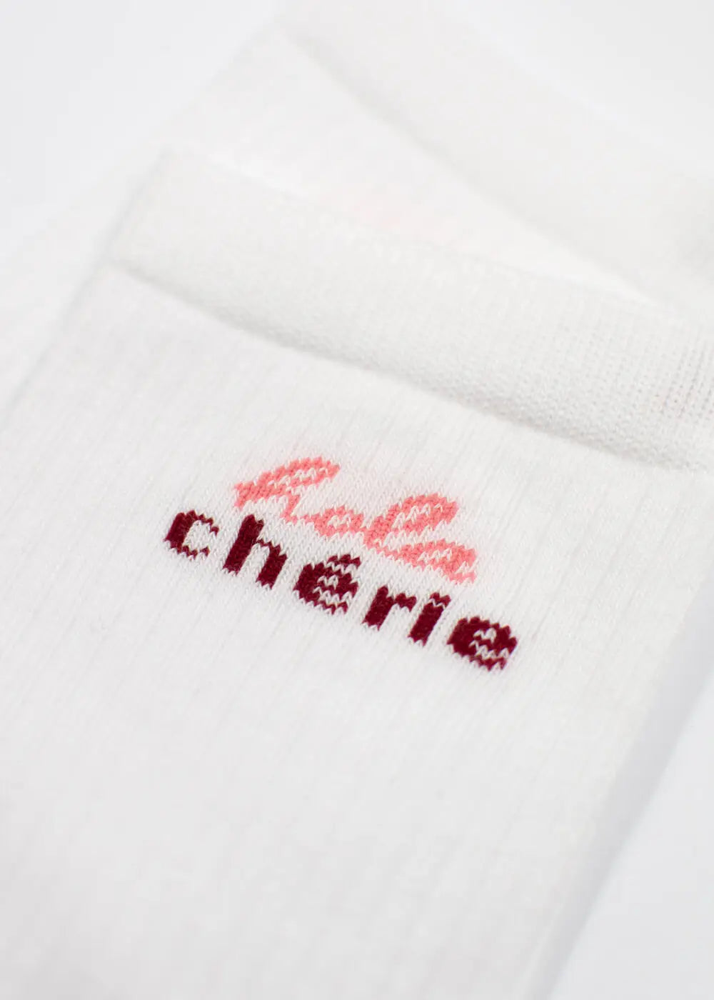 Weiße gerippte J.Clay Hola Chérie - Midi-Socken mit rosa und burgunderrotem Bébé Chérie-Text am Bündchen.