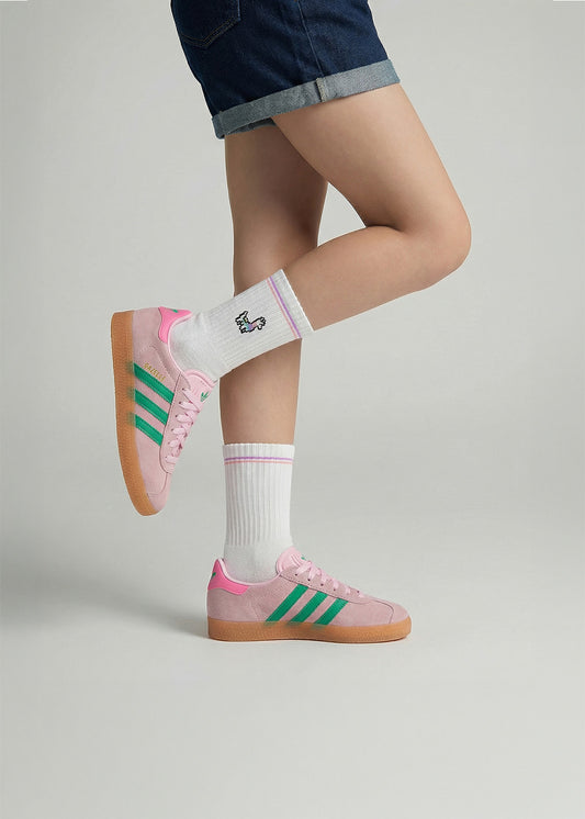 Die Person trägt J.Clay Lama - Kindersocken, rosa Turnschuhe mit grünen Streifen und Denim-Shorts.