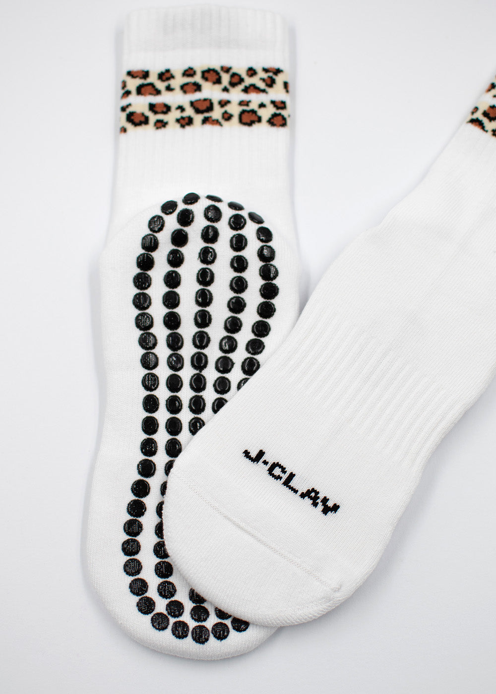 Leo Stripes Grip von J.Clay: weiße Socken mit Leopardenmuster und schwarzen Eco Grip-Punkten.
