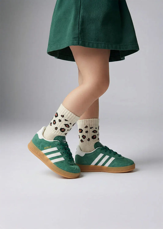 Person in grünem Rock trägt J.Clay Leo - Mini Babysocken und grüne Adidas-Sneaker.