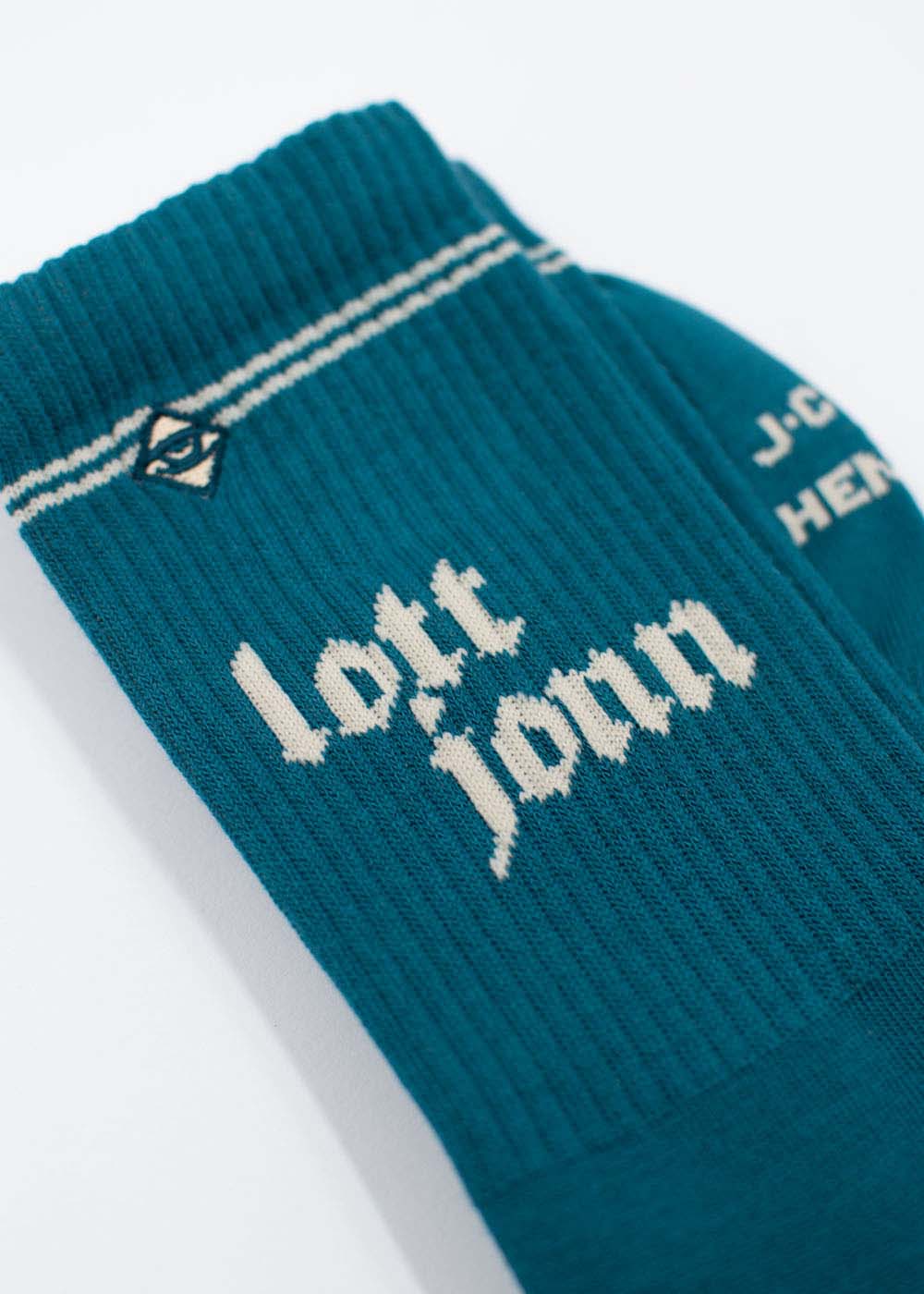 Socken von Teal J. Clay Lott Jonn 2.0 mit weißer Aufschrift und einem kleinen Augensymbol am oberen Rand.