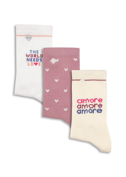 Drei Paar gerippte J.Clay-Tennissocken: ein weißes Paar mit dem Text "THE WORLD NEEDS LOVE", ein rosa Paar mit kleinen weißen Herzen und ein cremefarbenes Paar mit dem bunten Text "amore amore amore".