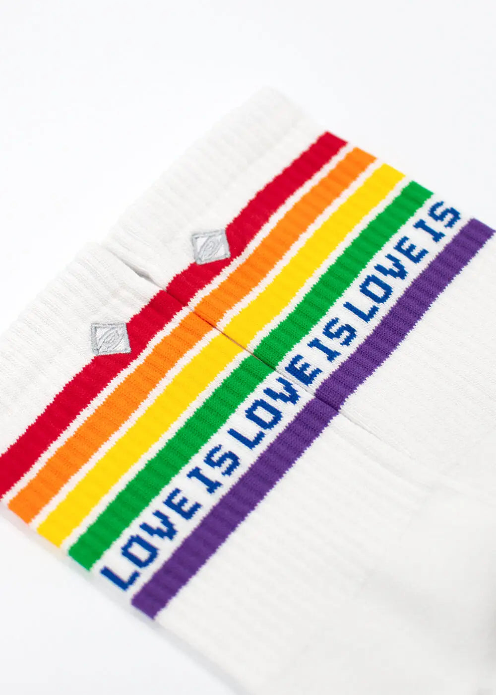 J.Clay Love is love Socken mit Regenbogenstreifen und blauem "LOVE IS LOVE IS" Text.