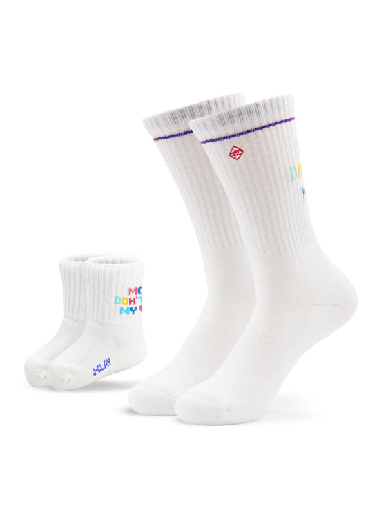 Zwei Paar weiße J.Clay-Socken - ein Paar für Erwachsene ("Mama Kind Socken") und ein Paar für Kleinkinder - für einen lustigen Partner-Look! Beide haben einen bunten Text, ein rotes, quadratisches Logo und das Paar für Erwachsene hat gerippte Bündchen mit lila Abschlüssen.